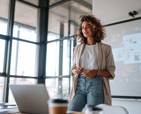 A young female professional giving a creative business presentation laptop workspace meeting.