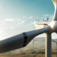 Happy engineer feel success after good work. He standing a top of windmill and looking beautiful sunset landscape